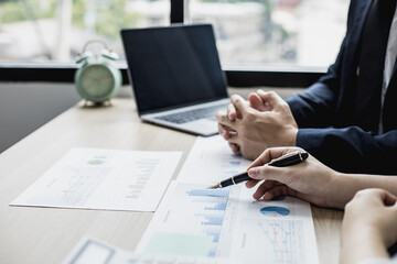 Fototapeta premium Two businessmen are reviewing monthly sales documents for analysis and marketing plans for more sales growth, they are the founders of young companies co-founding startups. Sales management concept.