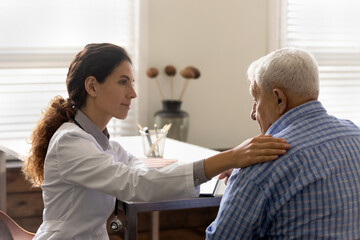 Caring female nurse touch support elderly male patient hear bad news results at hospital...