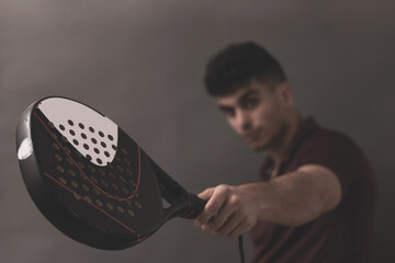 
a sporty boy posing with a paddle racket in a photo studio.
paddle and tennis