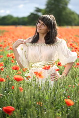 Naklejka na ściany i meble Young woman in poppies field