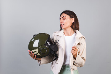 Woman in leather jacket and helmet on gray background