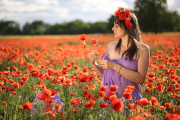 Obraz na płótnie Canvas Woman in poppies field