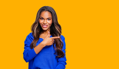 Closeup photo of beautiful African American Woman smiling indicate fingers empty space black Friday prices wear Blue clothes isolated bright orange color background.   