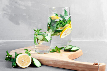 Obraz na płótnie Canvas Health care, fitness, healthy food concept. Fresh cool mint lemon cucumber pour water, cocktail, detox drink, lemonade in a glass jug. 