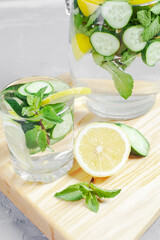 Fresh cool detox water drink with cucumber and lemon. glass of Lemonade with basil and mint leaves. Concept of proper nutrition and healthy eating. Fitness diet. Copy space for tex