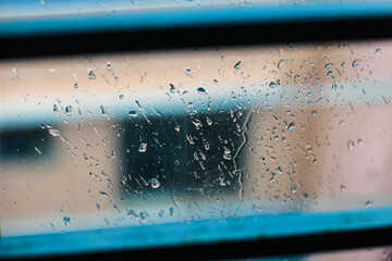 Drops of rain on blue glass background. drops on glass after rain for wallpaper. Drops on glass, window condensation, and the background for dark text.