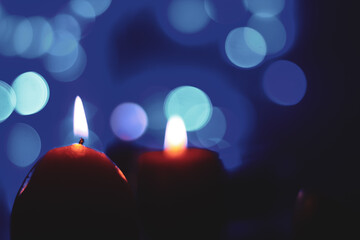 Candle lights in darkness with colorful light effects and bokeh for solemn moments and wallpaper....