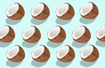 A coconut cut in half on a white, mirror background. - 441721876