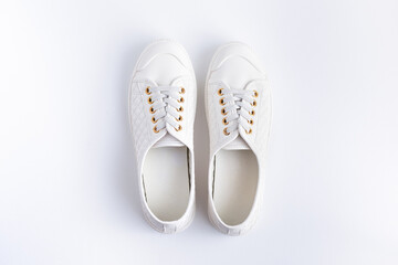 Women's white sneakers on a white background. View from above.