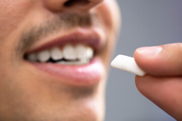 Man Using Nicotine Gum To Quit Smoking