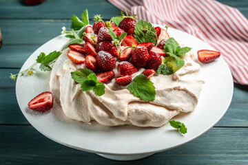pavlova meringue cake decorated with fresh strawberries and whipped cream. food, culinary, baking and cooking concept