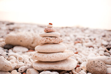 Stack of beach pebble stones at sea shore outdoors. Summer vacation season. Balance and stability lifestyle concept. Natural background and texture.
