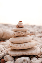 Fototapeta na wymiar Stack of beach pebble stones at sea shore outdoors. Summer vacation season. Balance and stability lifestyle concept. Natural background and texture.