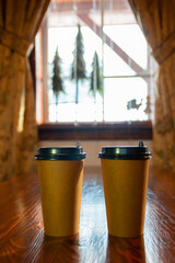Two paper cups on a table in a cafe