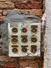 Vintage calls to different apartments on the background of an old red brick wall