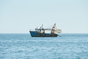 Fishing boat, trawler fishing Razor fish in an open Irish sea. Food industry, traditional craft,...