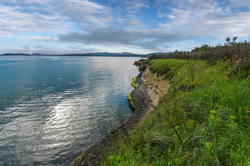 Seascape of the rocks at the coastline of Kraimorie, Burgas region, Bulgaria. The beautiful beach of the black sea with wild poppy flowers.