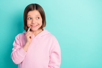 Photo of short hairdo cute small girl finger face look empty space wear pink sportswear isolated on teal color background