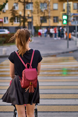 young woman in black clothes walks around the city with a stroller. A beautiful and thin mother on...