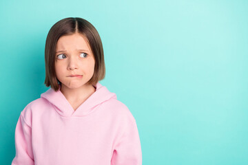 Photo of sad short hairdo little girl look empty space wear pink sportswear isolated on teal color background