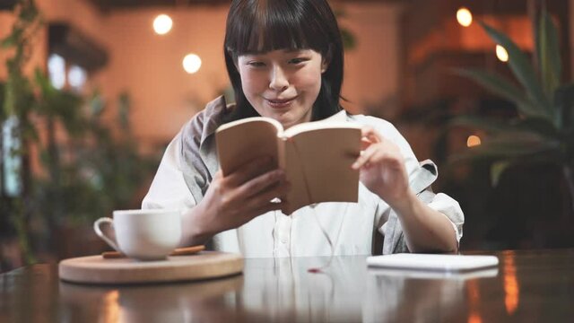 暖かい雰囲気の空間で、本を読む若い女性
