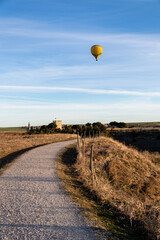 Fototapeta na wymiar A road, a castle, a blue sky and a balloon