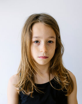 Girl with long hair and freckles against white background