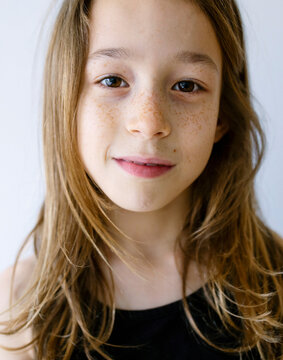 Happy girl with long hair and freckles against white background