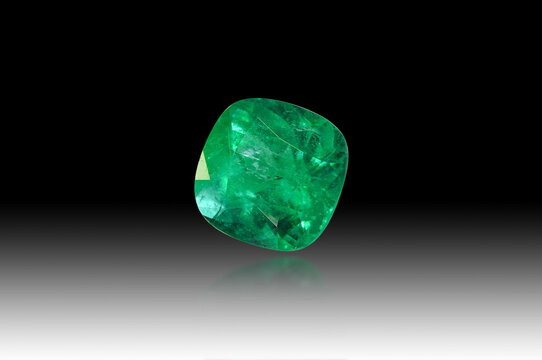 Natural Colombian emerald beryl transparent rich green color cushion faceted loose gemstone setting for jewelry making. Isolated on black gradient background, blured reflection. Gemology theme.