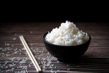 rice is in a bowl and chopsticks.It full of carbohydrate.It is chinese japanese culture.