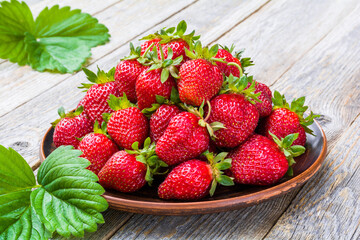 Fresh strawberries on a plate on a wooden table