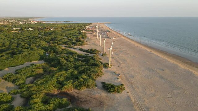 Aerial shot of golden beach meeting deep blue ocean water and foamy waves