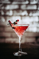 Delicate women's red cocktail in martinka with flowers Spring or summer strawberry alcohol