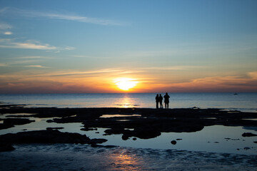 silhouette of a person on a beach at sunset