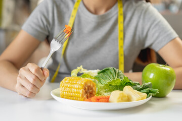 Diet, Dieting young asian woman or girl use fork at carrot on vegetables salad plate, eat green food is low fat good health not choose eat junk food. Nutritionist female, Weight loss person.