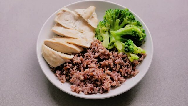 dolly shot Riceberry, boiled chicken breast and Broccoli on whiteplate