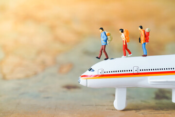 Miniature people: A traveler mini figures with backpack standing on Global World map balloon. Success Business Due around the world and Traveling agency concepts.
