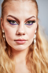beautiful girl in bright makeup on a gray background