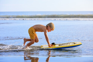 Boy with bodyboard have fun on sea beach - obrazy, fototapety, plakaty