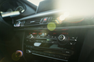 Black premium car interior. Dashboard, steering wheel, speedometer at sunny day