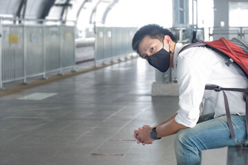 Asian traveler business man wearing face mask indeparture terminal in airport. Male passenger traveling by plane transportation during covid19 virus pandemic. vacation concept.