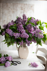 Bouquet of lilacs in a vintage basket. Beautiful violet Lilac flower still life Easter border design on wooden table.