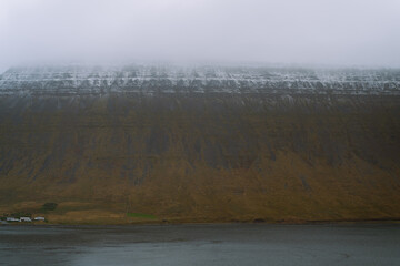 West Fjords or The Westfjords is region in north Iceland. Dramatic moody sky nature landscape. Low clouds on mountains