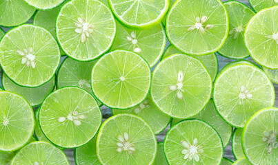 Lime slices background,Lemon and green lime overlapped slices close-up background,Macro close up surface texture Juicy slice of lime