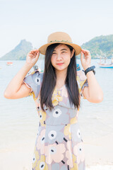 young woman wearing a hat on the beach,A portrait of happy asian girl jumping and holding hat at the beach, good vacation in summer , Phuket ,Thailand