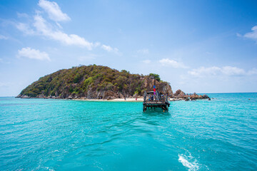 Boats and islands in Thailand,Colorful traditional long tail boat floating on tropical blue turquoise crystal clear water, white sand beach and lush green mountain at Chaloklum beach in Phangan Island