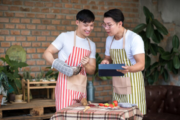 Men using tablet while cooking in the kitchen