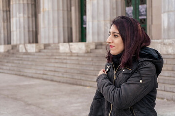 Fototapeta premium Outdoor portrait of young pretty beautiful woman in cold cloudy winter weather.