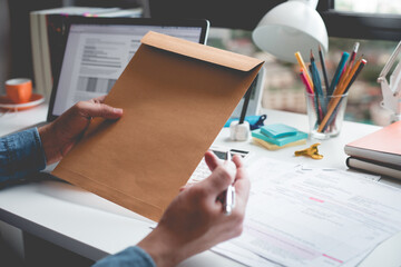 Fototapeta premium Businessman holding document envelope on desk table.