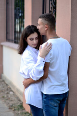 Lovers young guy and girl in white shirts hugging